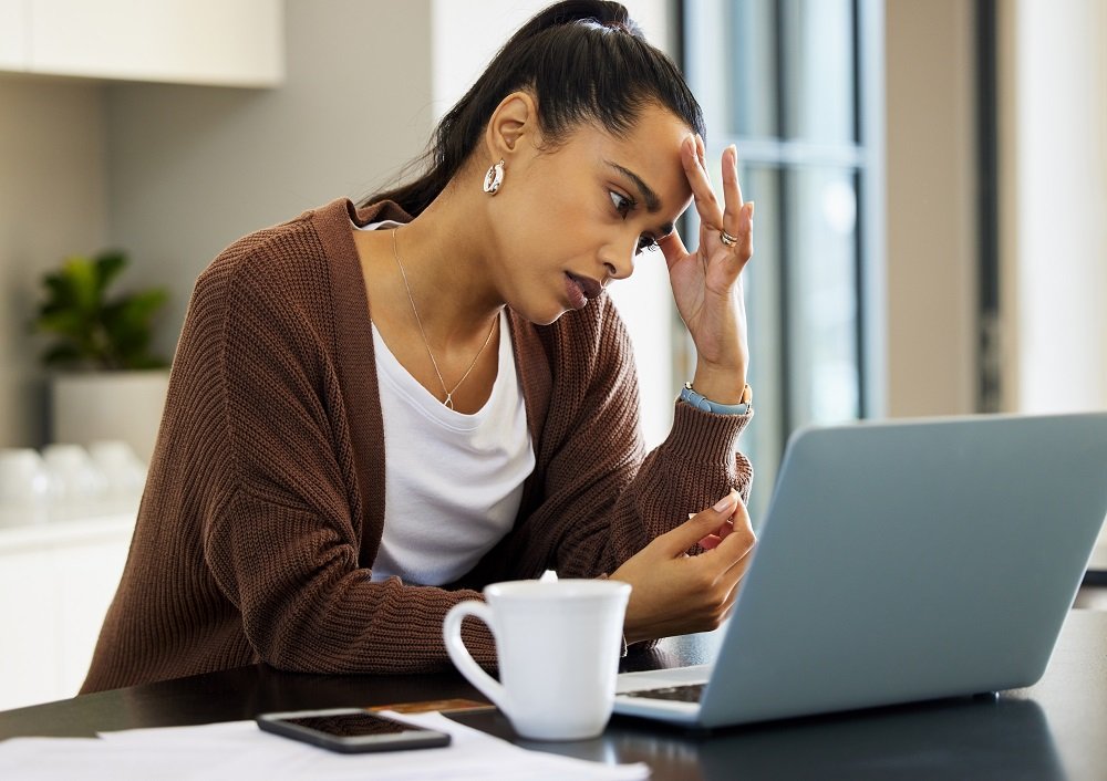 Mulher preocupada com a crise, em frente ao computador