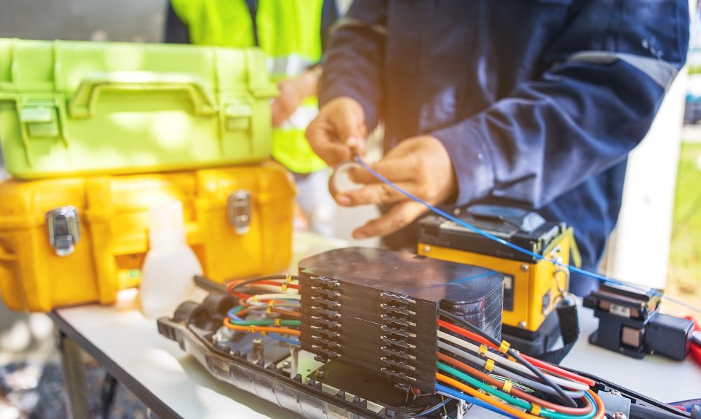 Engenheiro de ISP usando máquina de fusão de fibra óptica.