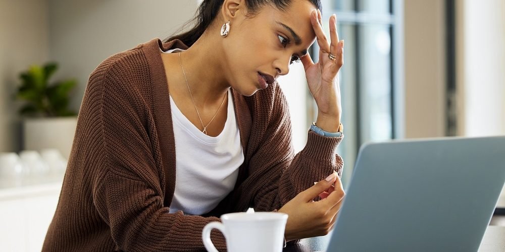 Mulher preocupada com a crise, em frente ao computador